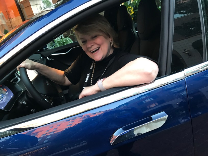 a woman in a blue Tesla