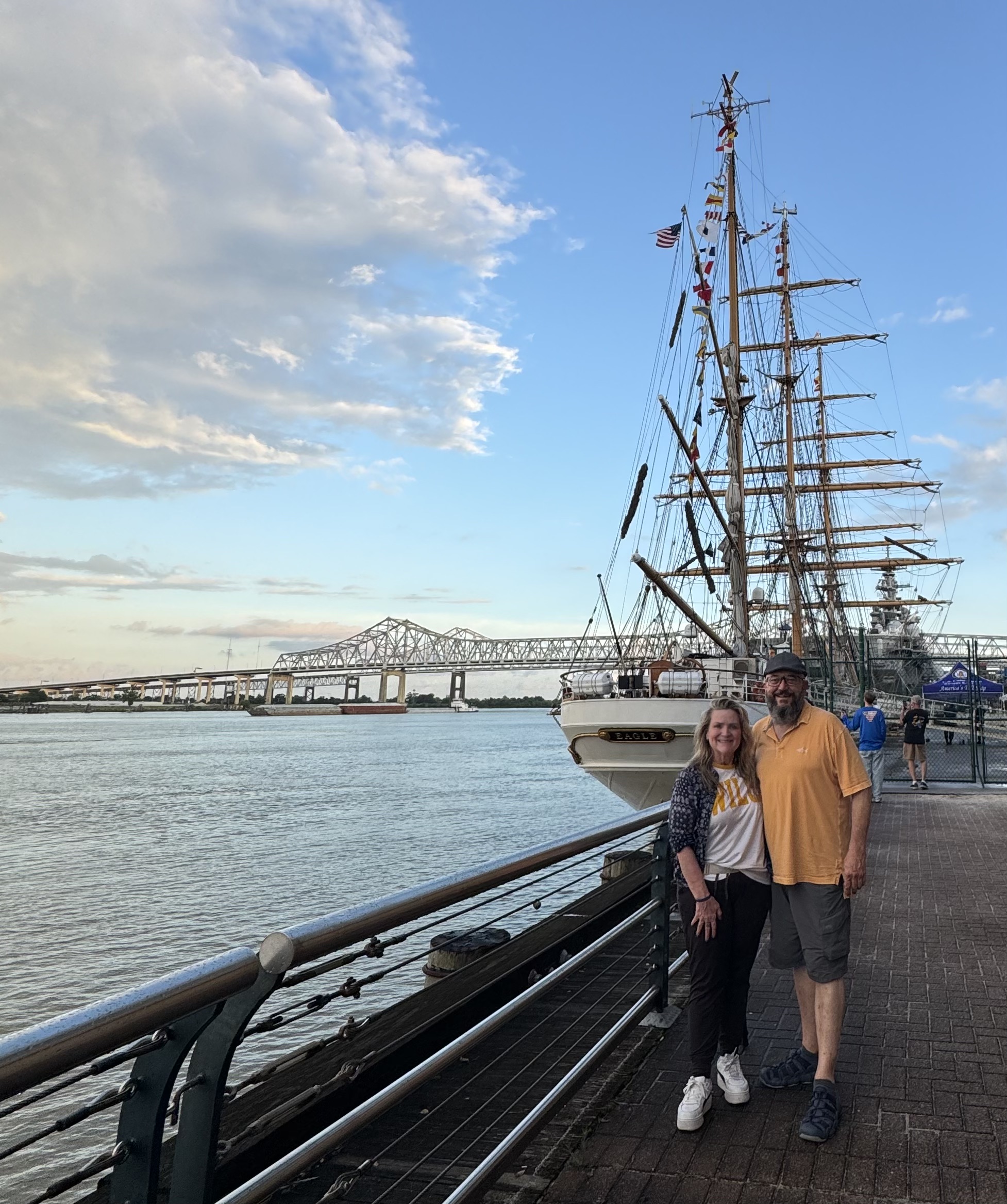 a man and woman standing in front of the U.S. Coast Guard Eagle, the largest American Tall Ship