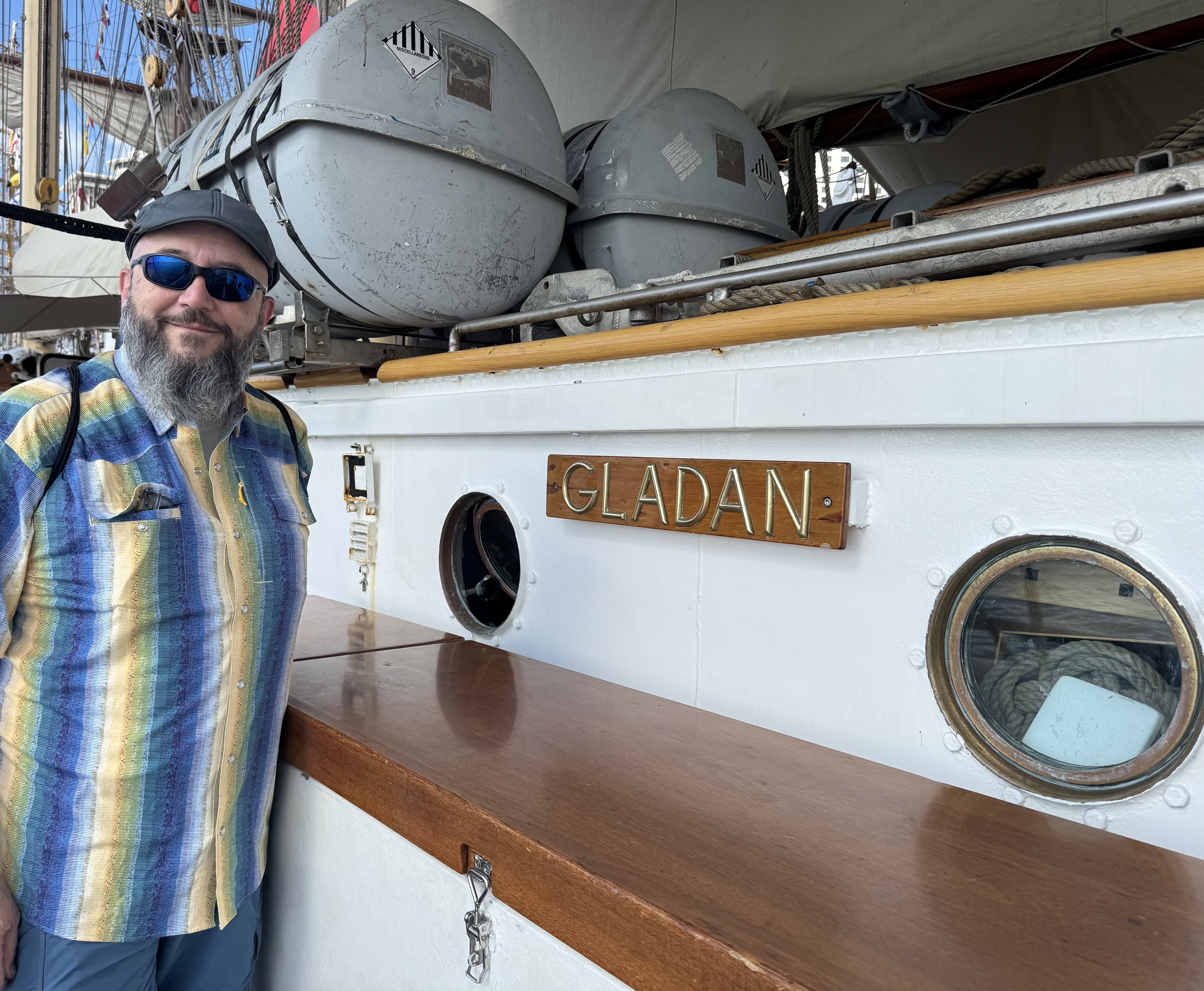 A man standing in front of the Gladan - Swedish Ship sign