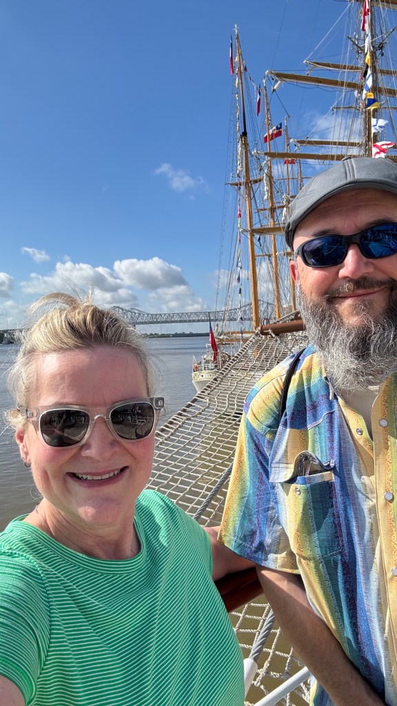 A man and woman standing in front of Sail250 Tall Ships