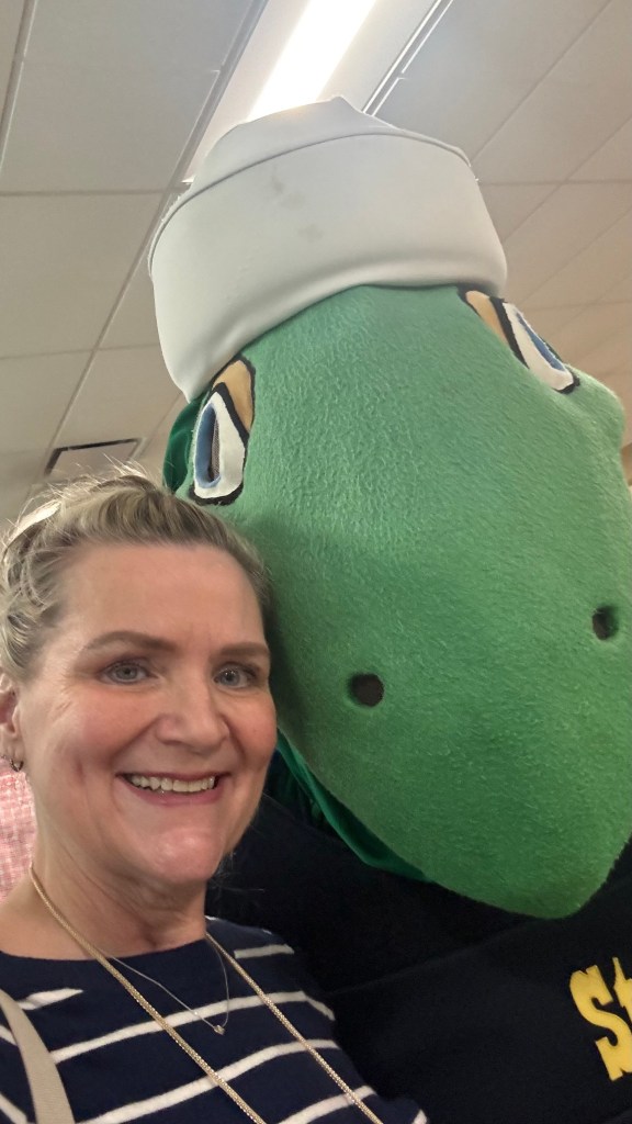 A woman taking a selfie with a Navy mascot