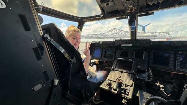 a woman in the flight seat of a military vehicle