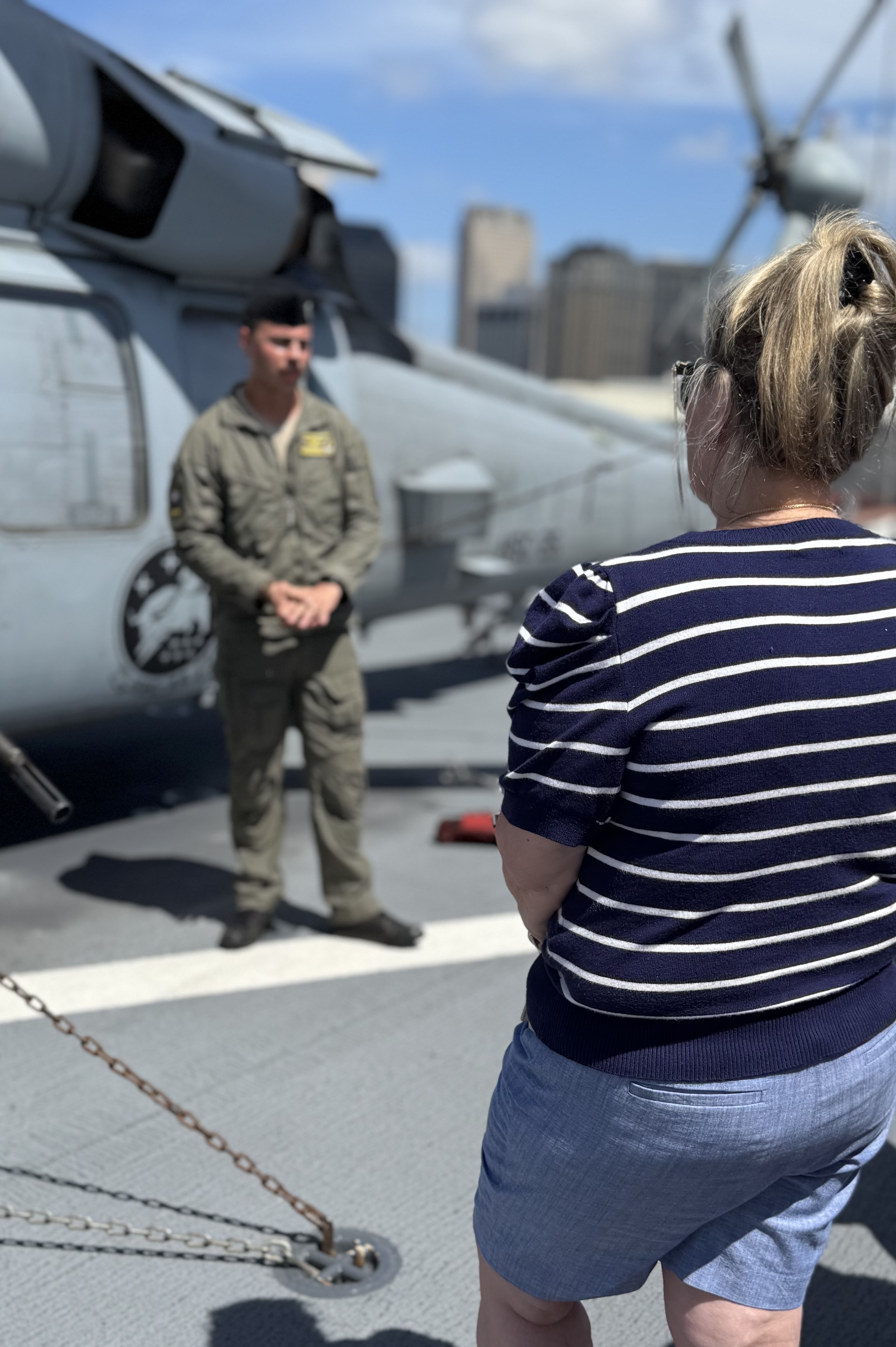 a woman listening to a naval pilot on the flight deck of the USS Kearsarge