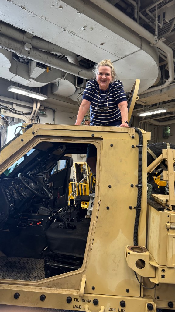 a woman atop a military vehicle in the USS Kearsarge