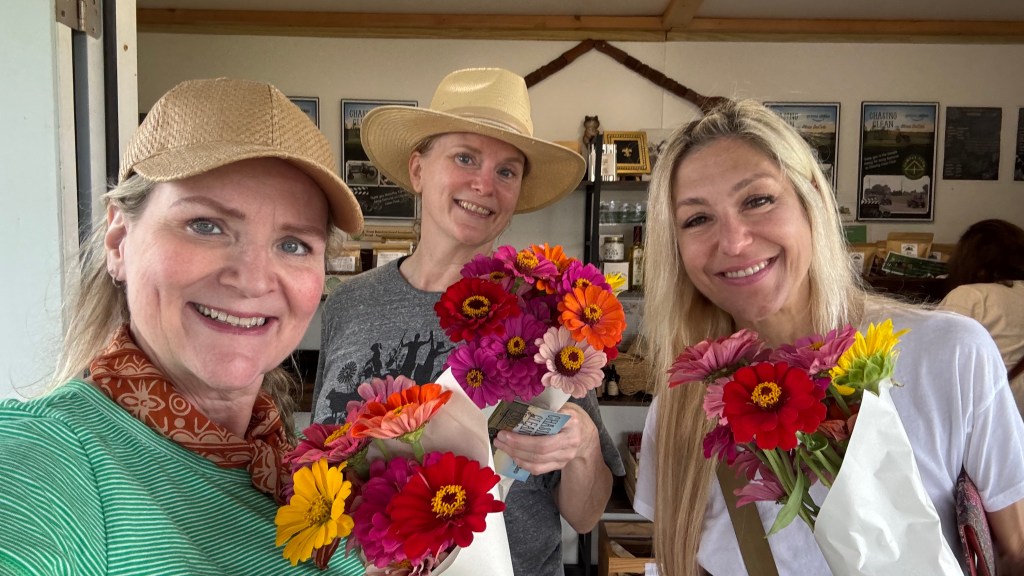 Members of Slow Food North Louisiana holding fresh-cut zinnia bouquets at Raccoon Bend Farms.