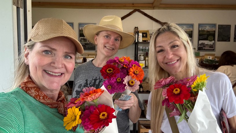 Members of Slow Food North Louisiana holding fresh-cut zinnia bouquets at Raccoon Bend Farms.